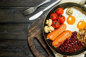 traditionell Englisch Frühstück mit gebraten Eier, Würste und Bohnen. foto