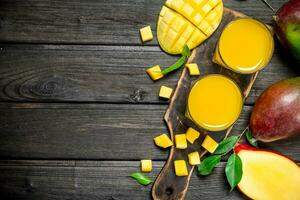 Mango Saft im ein Glas auf ein Schneiden Tafel. foto