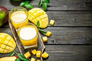 Mango Saft und Scheiben von frisch Mango auf das Schneiden Tafel. foto