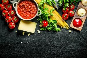 Pasta Hintergrund. trocken Spaghetti mit Bolognese Soße, Kräuter, Tomaten und Käse. foto