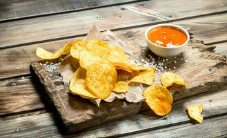 Kartoffel Chips auf alt Papier mit Tomate Soße. foto