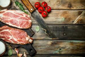 roh Schweinefleisch Steaks mit Tomaten und Gewürze. foto