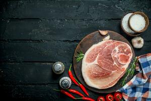 groß roh Schweinefleisch Steak mit Gewürze und Gemüse. foto