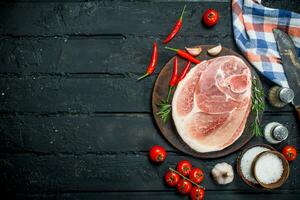 groß roh Schweinefleisch Steak mit Gewürze und Gemüse. foto