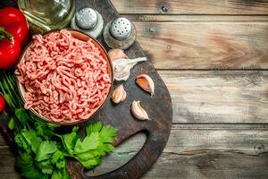 roh gehackt Fleisch im ein Schüssel mit Petersilie, Tomaten und Knoblauch. foto