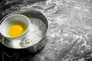 Mehl im Sieb mit Ei. foto