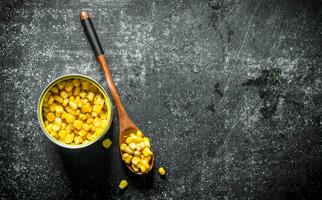 Zinn können und Löffel mit Dosen- Mais. foto