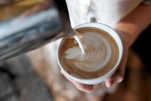 Barista, der Latte-Art-Kaffee kreiert. foto