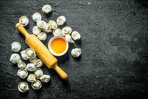 roh Knödel mit ein rollen Stift und ein Ei. foto