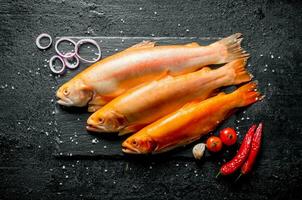 roh Fisch Forelle mit Chili Pfeffer, Tomaten und Zwiebel Ringe. foto