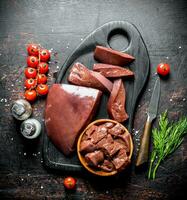 roh Leber mit Kirsche Tomaten, Gewürze und Dill auf ein Schneiden Tafel. foto