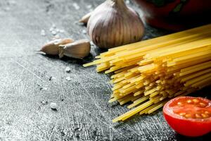 roh Spaghetti mit Knoblauch Nelken und Tomate. foto