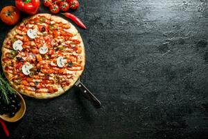 Pizza mit Oliven, Würste und Tomaten. foto