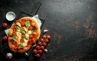 hausgemacht Pizza mit Gewürze, Tomaten und Knoblauch. foto