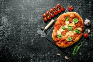 hausgemacht Pizza mit Tomaten auf ein Ast und Rosmarin. foto