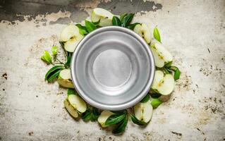 leeren Tasse mit geschnitten Grün Äpfel auf ein rustikal Hintergrund. foto