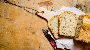 Brot mit Kräuter und Messer auf Tafel. foto