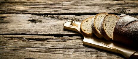 geschnitten Roggen Brot auf ein Tafel. auf hölzern Tisch. foto