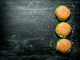 drei Burger mit Fleisch, Käse und frisch Gemüse. foto