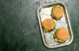 Burger von frisch Rindfleisch und Gemüse mit anders Saucen auf ein Stahl Tablett. foto