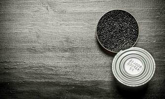 schwarz Kaviar im ein Krug . auf schwarz hölzern Tisch. foto