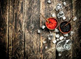 Wodka im ein Flasche mit schwarz und rot Kaviar. foto