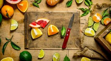 geschnitten Zitrusfrüchte Früchte - - Grapefruit, orange, Mandarine, Zitrone, Limette auf das alt Tafel mit Kasten. foto
