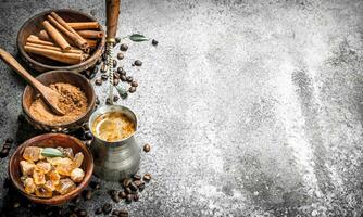 Kaffee Hintergrund. Kaffee im Truthahn mit Kristalle von Zucker, Zimt und Boden Kaffee. foto