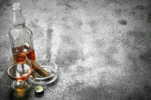 Glas von Cognac mit ein Zigarre. foto