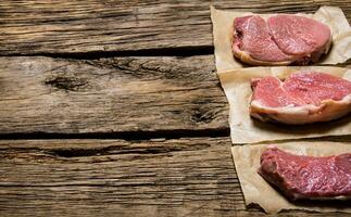 Steaks von roh frisch Fleisch. auf hölzern Hintergrund. foto