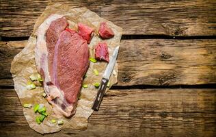 frisch roh Fleisch mit ein Metzger Messer. foto