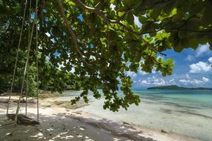 Holzschaukel an einem leeren Strand in Koh Ta Kiew Paradise Island in der Nähe von Sihanoukville in Kambodscha foto