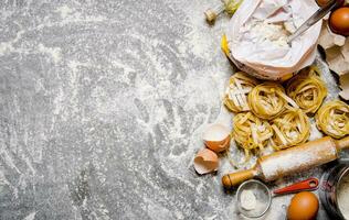 Pasta mit Zutaten - - Mehl, Eier und anders Werkzeuge zum Kochen. foto