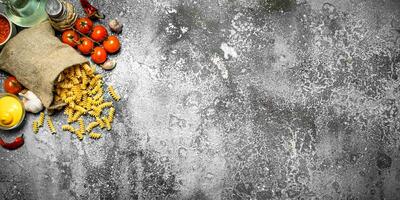 Pasta Hintergrund. Pasta mit Saucen, Gemüse und Olive Öl. foto