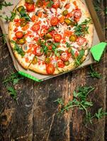 frisch Pizza mit Tomaten und Grüns. foto