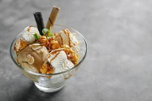 Karamell-Mandel-Eis mit karamellisiertem Popcorn-Eisbecher-Dessert in Glasschale foto