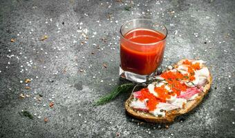 Sandwich mit Krabbe Fleisch, rot Kaviar, Gemüse und ein Glas von Tomate Saft. foto