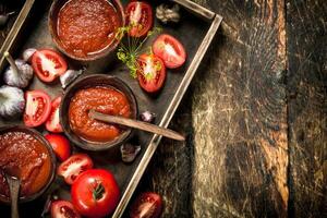 Tomate Soße mit Gewürze und Knoblauch im das alt Tablett. foto