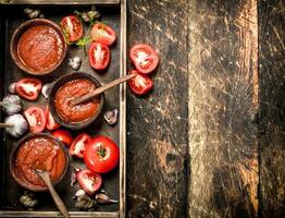 Tomate Soße mit Gewürze und Knoblauch im das alt Tablett. foto