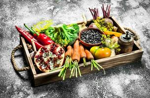 organisch Lebensmittel. frisch Gemüse und Früchte auf ein hölzern Tablett. foto