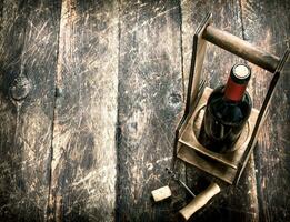 Wein Hintergrund. ein Flasche von rot Wein auf ein Stand mit ein Korkenzieher. foto