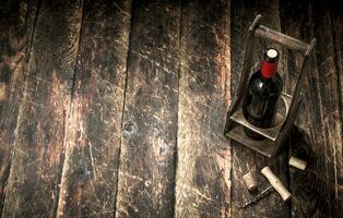 Wein Hintergrund. ein Flasche von rot Wein auf ein Stand mit ein Korkenzieher. foto