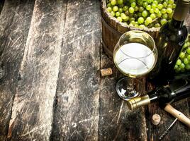Weiß Wein mit ein Eimer von Grün Trauben. foto