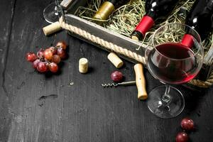 Wein Hintergrund. rot Wein im ein alt Box mit ein Korkenzieher. foto