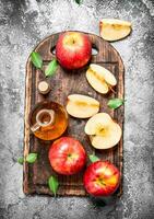 Apfel Apfelwein Essig mit frisch Äpfel auf Schneiden Tafel. foto