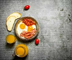 Speck, gebraten Eier mit Bohnen und Orange Saft. foto