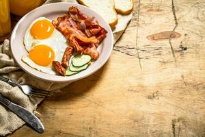 Orange Saft mit gebraten Eier, Speck, und Scheiben von Brot. foto