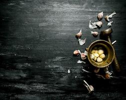 Knoblauch Hintergrund. frisch Knoblauch und ein Granatwerfer mit Stößel. foto
