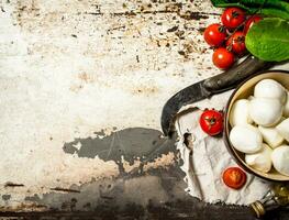 Mozzarella Käse, Tomaten, Olive Öl und ein alt Messer. foto