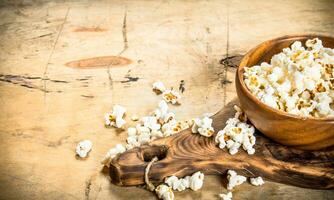 Popcorn im ein hölzern Schüssel auf das Tafel. foto